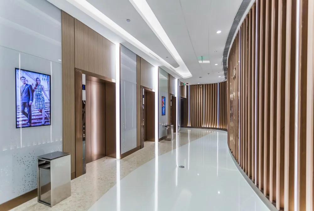 Commercial passenger lifts in a timber-lined building lobby